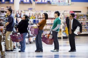 People waiting in line with shopping baskets at grocery store